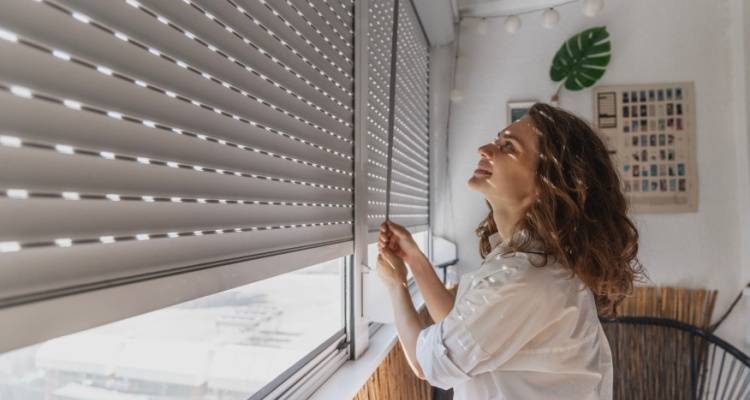 woman closing blinds