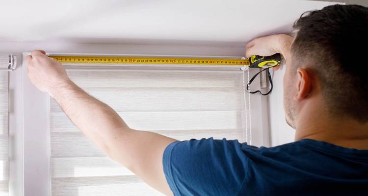 man hanging curtains