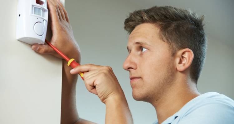 person fitting a security sensor