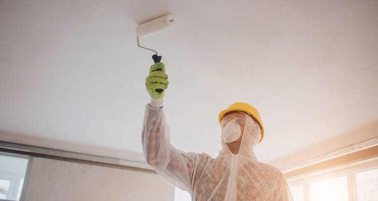 man painting with PPE on