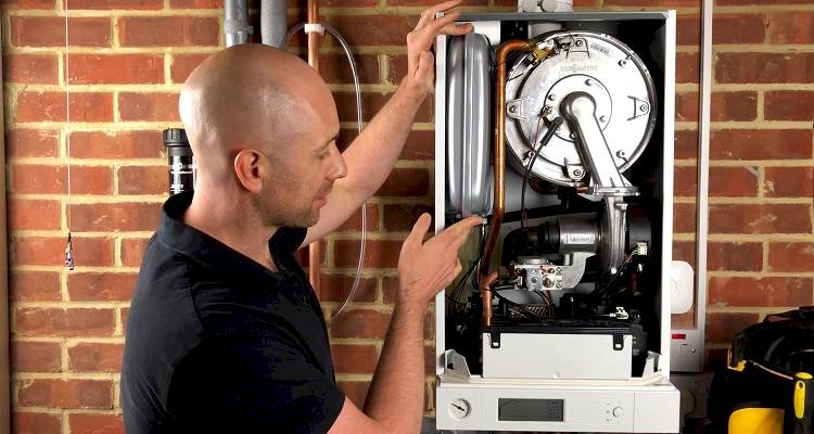 boiler installation cost guide — tradesperson conducting a boiler service