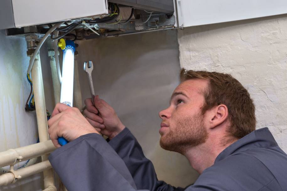 person repairing under boiler