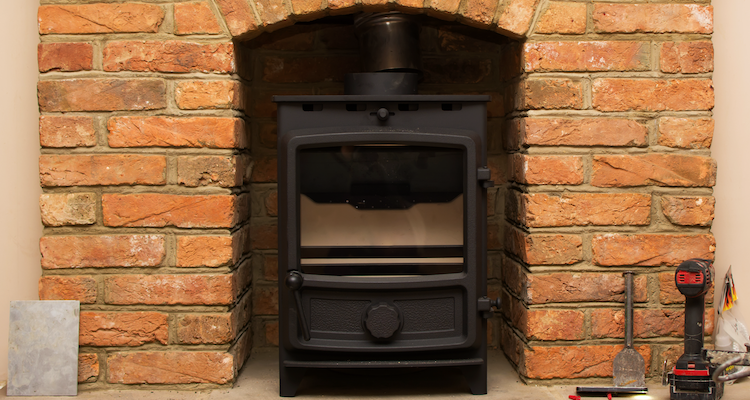 log burner installation being completed in an existing brick space