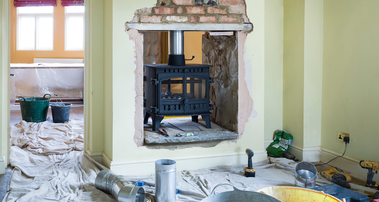 wood burning stove being installed in the middle of the room in the UK