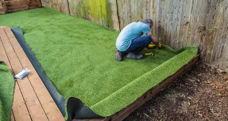 tradesperson laying artificial grass