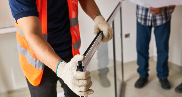 window fitting specialist holding a pane of glass before installation