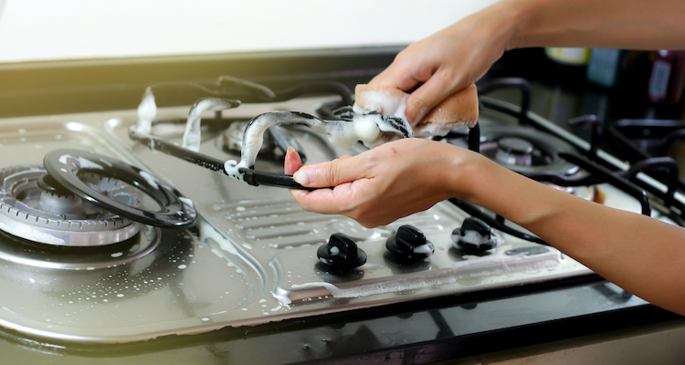 professional oven cleaner who is cleaning components of a small cooker