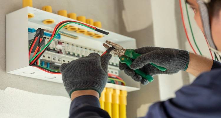 electrician checking fuse board