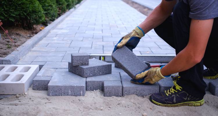 person laying block paving