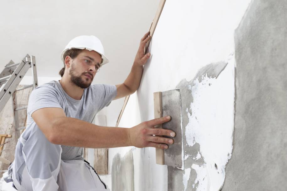 person plastering wall