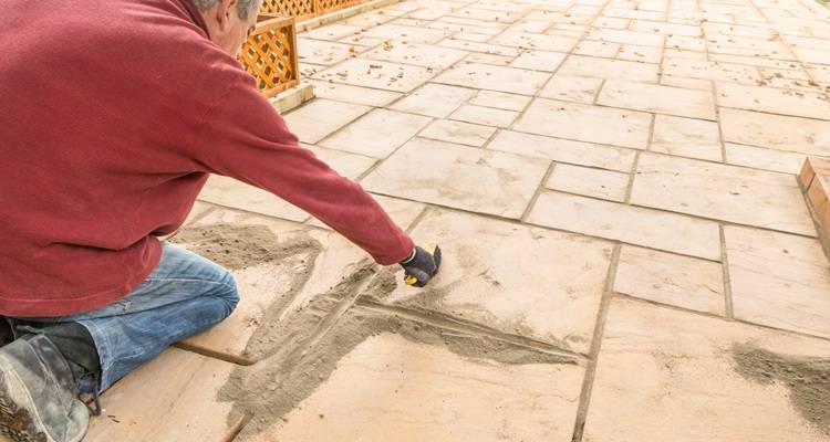 man repointing patio