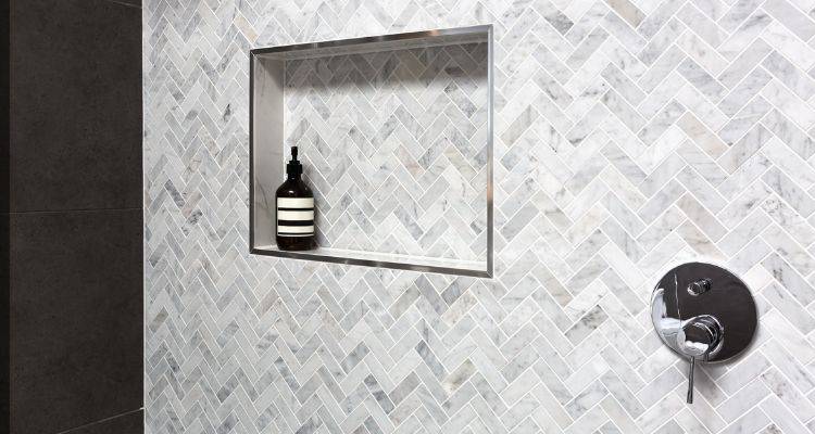 shower with grey and white marble herringbone tiles