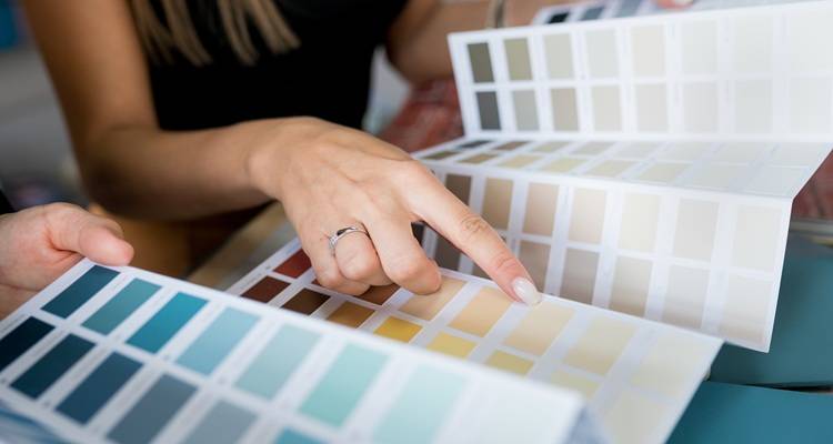 Woman looking through paint charts